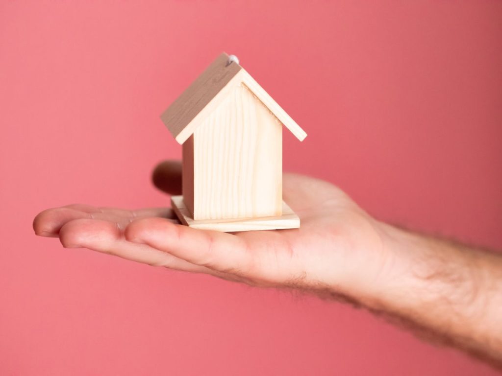 Mô hình căn nhà nhỏ giá rẻ trong lòng bàn tay, tượng trưng cho bất động sản giá rẻ
